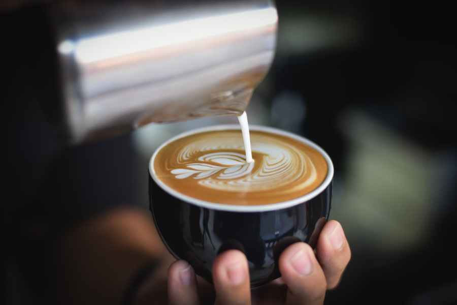 close up of woman holding coffee cup at cafe